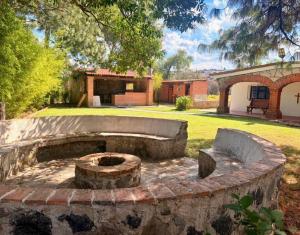 a stone fire pit in the yard of a house at La isla encantada in Aculco de Espinoza