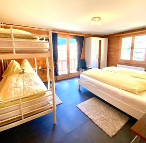 a bedroom with two bunk beds and a window at Apartments Chalet Tatyana in Leukerbad