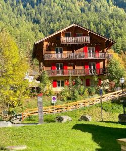 a large wooden building with balconies on a mountain at Apartments Chalet Tatyana in Leukerbad