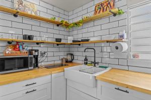 a kitchen with a sink and a microwave at Perfect Group Retreat for 10 Near Beach & Airport in Carolina