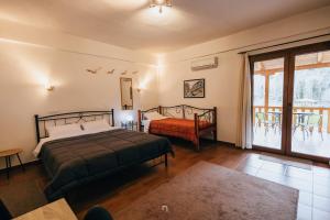 ein Schlafzimmer mit zwei Betten und einem großen Fenster in der Unterkunft Michel Studios in Kalavryta