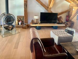 a living room with a tv and a couch at Chalet Lucien, Jacuzzi, Les 3 Vallées in Villarly