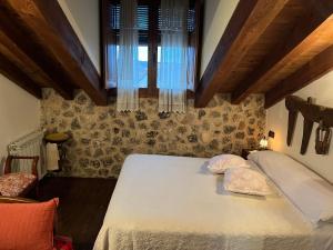 a bedroom with a bed with two pillows on it at Casa del Herrador II in Carrascal del Río