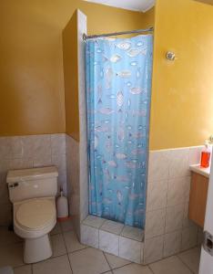 a bathroom with a shower curtain with a toilet at Apartamento playa Tonsupa in Tonsupa