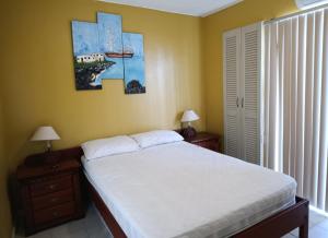 a bedroom with a bed and two lamps and a window at Apartamento playa Tonsupa in Tonsupa