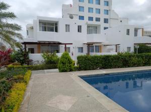 a house with a swimming pool in front of a building at Apartamento playa Tonsupa in Tonsupa +5 photos