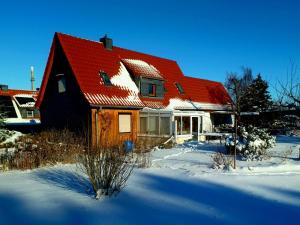 a house with a red roof in the snow at Ferienhaus Rosi in Blankenburg