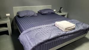 a bed with purple sheets and pillows in a bedroom at Dan Mai Homestay in Trat