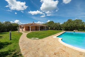 a house with a swimming pool in the yard at Villa Del Sole- in Costa Rei