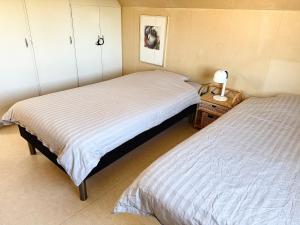 a bedroom with two beds and a lamp on a night stand at Villa in central Visby in Visby