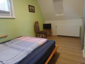 a bedroom with a bed and a chair and a desk at Ferienhaus Rosi in Blankenburg