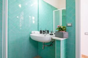 a blue tiled bathroom with a sink and a mirror at Villa Del Sole- in Costa Rei +34 photos