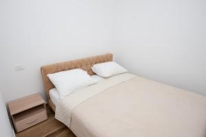 a bed with two pillows on it in a room at Apartmani Ivo 2 in Podstrana