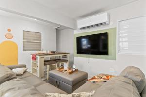 a living room with two couches and a flat screen tv at Perfect Group Retreat for 10 Near Beach & Airport in Carolina