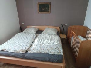 an unmade bed in a bedroom with a crib at Ferienhaus Rosi in Blankenburg