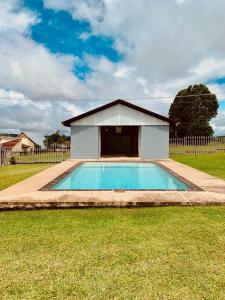 a small swimming pool in a yard with a building at Eindelik on de Lange in Graskop
