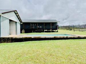 a house with a pool in the middle of a field at Eindelik on de Lange in Graskop