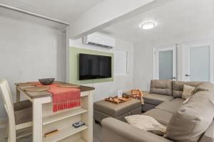 a living room with a couch and a tv at Perfect Group Retreat for 10 Near Beach & Airport in Carolina