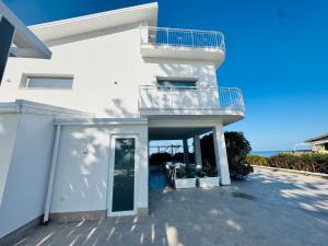 a white house with a staircase and a balcony at Al Grande Pino - Private pool, Jacuzzi and amazing Sunset in Campofelice di Roccella