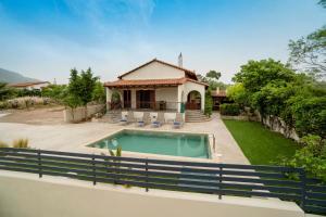 a house with a swimming pool in a yard at Villa Olivia in Loutraki