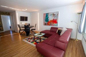 a living room with a red couch and a table at Panorama Apartments - Steinbock Lodges in Zell am See