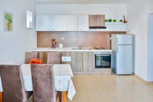 a kitchen with a table and a refrigerator at Apartment Petra in Senj