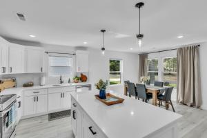 a white kitchen with a table and a dining room at 3 BR Downtown Spartanburg- Upscale& Work Ready "Sweet Carolina Cottage" in Spartanburg