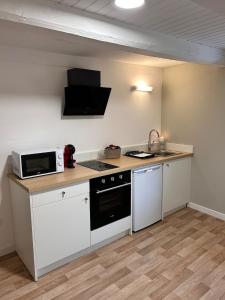 a kitchen with a stove and a microwave at Le petit cocon in Pont-de-Veyle