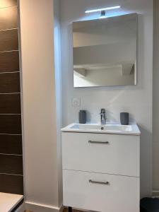 a white bathroom with a sink and a mirror at Le petit cocon in Pont-de-Veyle +1 photo