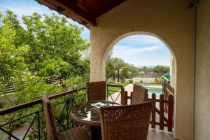 a patio with a table and chairs on a balcony at Villa Olivia in Loutraki