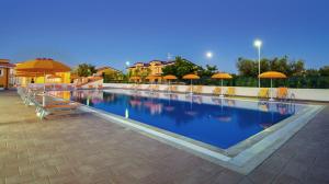 una gran piscina con sillas y sombrillas en Residence Villaggio Alemia, en Cropani