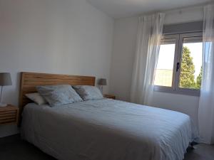 a bedroom with a large bed with a window at Apartamento Gandiaport in Gandía