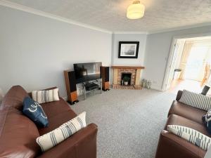 a living room with a couch and a television at Poole Harbour View in Poole