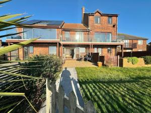 a large brick house with a fence in front of it at Poole Harbour View in Poole