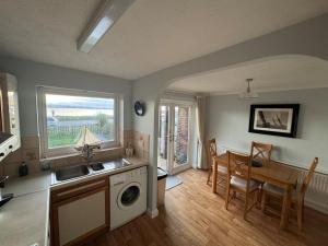 a kitchen with a sink and a table with a washing machine at Poole Harbour View in Poole