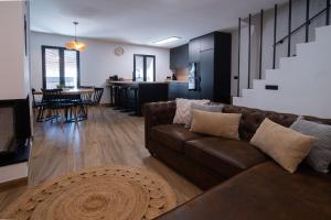 a living room with a brown couch and a kitchen at Casa Los Yayos in Segorbe