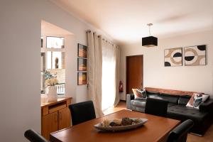 a living room with a table and a couch at Solful at the Nomads Village Ponta do Sol in Ponta do Sol
