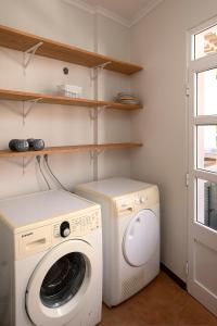 a laundry room with a washing machine and a window at Solful at the Nomads Village Ponta do Sol in Ponta do Sol