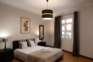 a bedroom with a bed and a window at Solful at the Nomads Village Ponta do Sol in Ponta do Sol