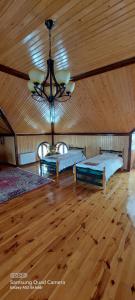 a bedroom with two beds and a ceiling with a chandelier at Villa Qeçreş in Quba