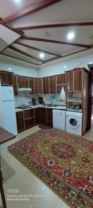 a kitchen with a large rug on the floor at Villa Qeçreş in Quba