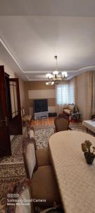 a living room with a bed and a living room with a television at Villa Qeçreş in Quba