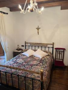 a bedroom with a bed with a cross on the wall at Casa del Herrador I in Carrascal del Río