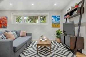 a living room with a couch and a tv at Entire Home - 2 Separate Units in Calgary