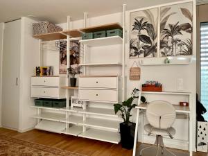 a white closet with shelves and a chair in a room at Studio Horizon Dorigny in Lausanne
