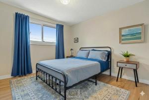 a bedroom with a bed with blue drapes at Entire Home - 2 Separate Units in Calgary