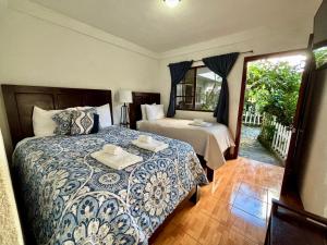 a bedroom with two beds and a window at Hotel & Restaurant Fleur de Lis in Concepción de Ataco