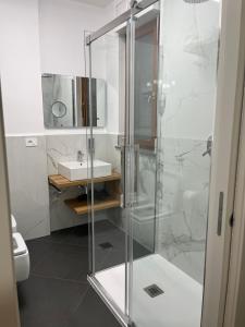 a bathroom with a glass shower and a sink at Olympic Lodge in Milan +18 photos