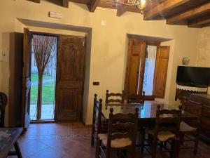 a dining room with a table and chairs and a television at Casa del Herrador I in Carrascal del Río