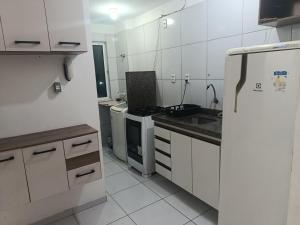 a kitchen with white cabinets and a refrigerator at Rogerio AP Compartilhado in Caucaia